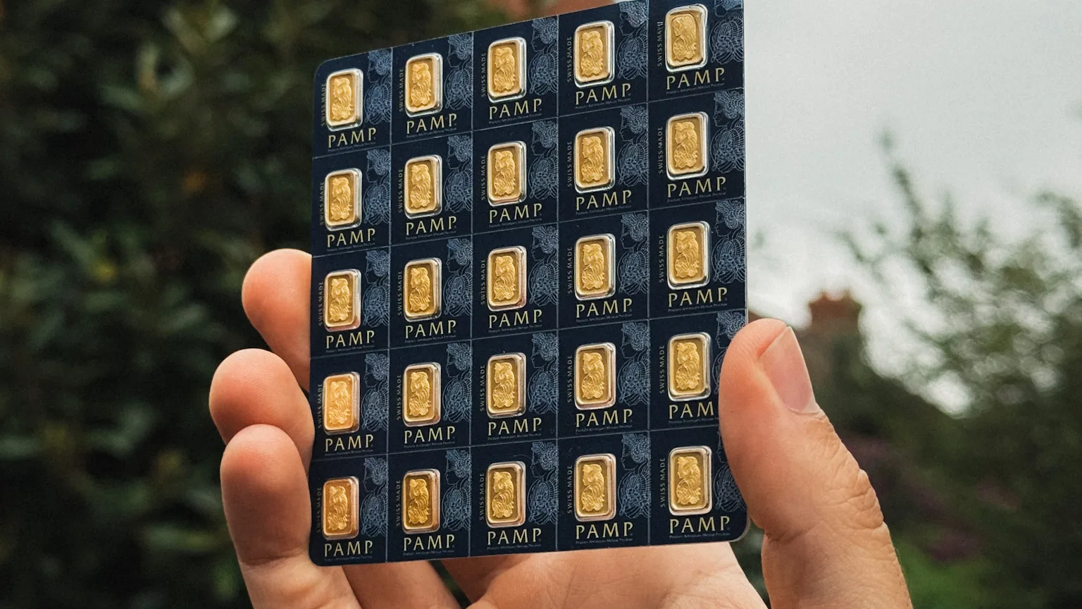 A PAMP Multigram sheet of 25 sealed 1 g bars, held up against the sky