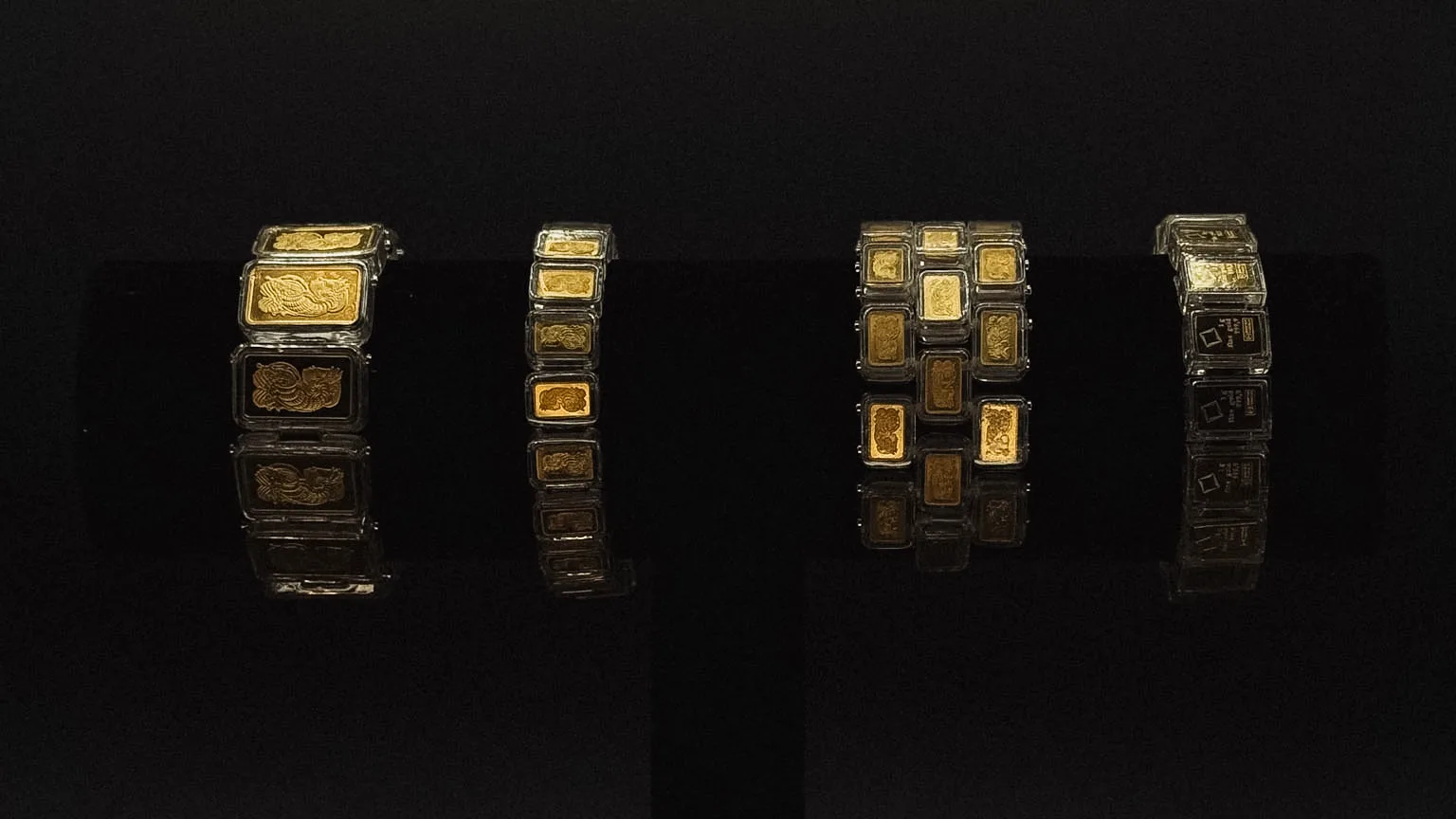 Four bracelets on a black stand, each built around bars of a different size
